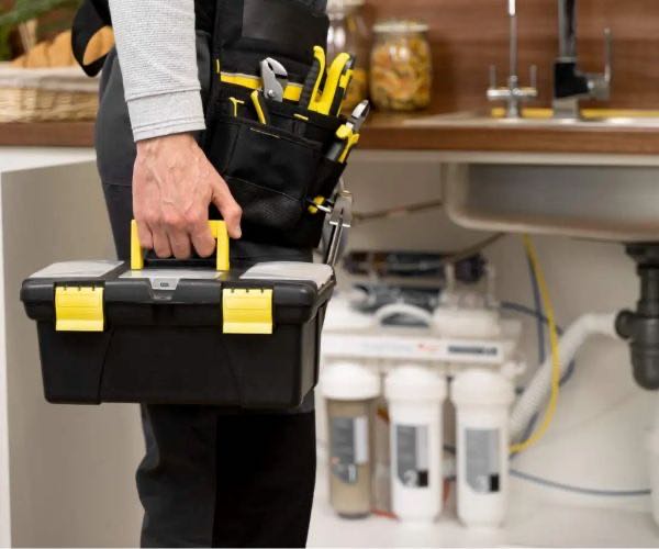 Erfahrener Installateur mit professionellem Werkzeugkoffer beim Kundeneinsatz in Österreich